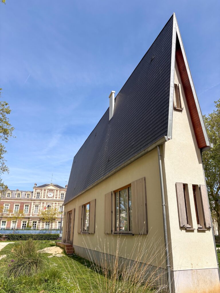 une maison toute fine au premier plan avec derrière un bâtiment de la ville du Havre