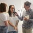 L'animateur Dominique Lowe sur la droite de la photo tient un micro en main et interview deux personnes.