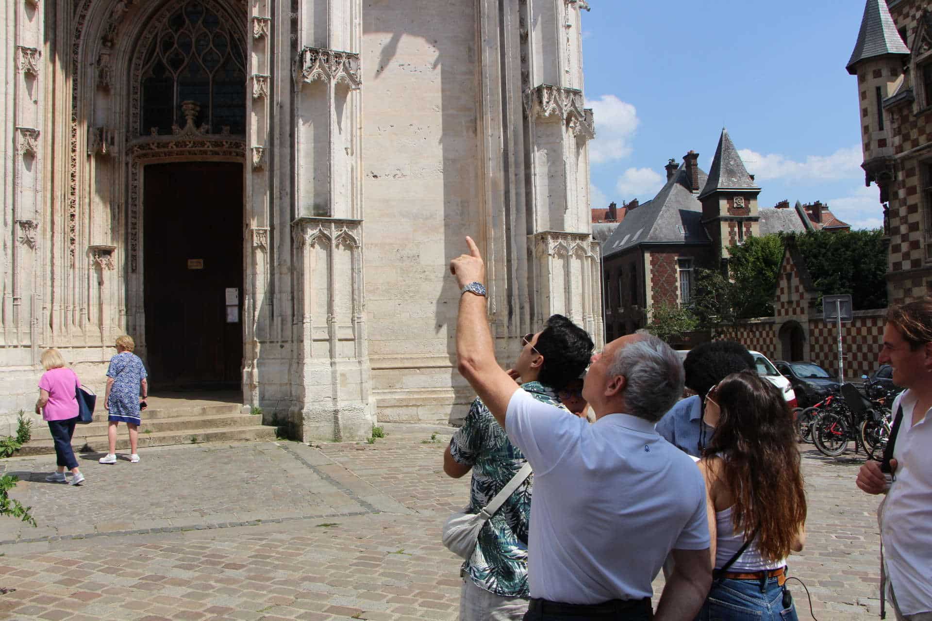 Les joueurs sont à la recherche d'une balise devant l'Eglise St Maclou. Le chef d'équipe montre du doigt le bâtiment.