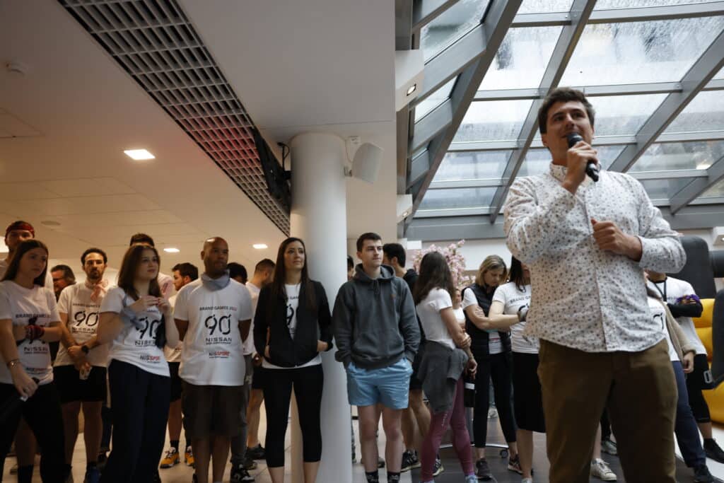 Plusieurs personnes participent à un quiz lors d’un séminaire d’entreprise En arrière plan: plusieurs joueurs participent à un blind test. Au premier plan l'animateur Dominique Lowe anime l'évenement, dicte les questions et distribue les points.