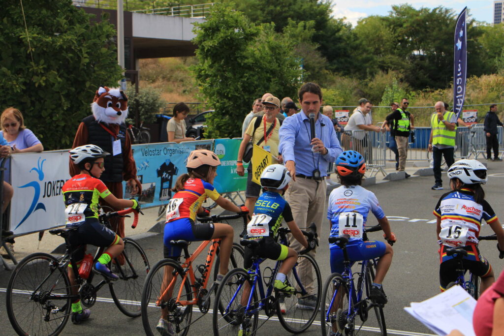 Cinq élèves cyclistes attendent le top départ devant le speaker.