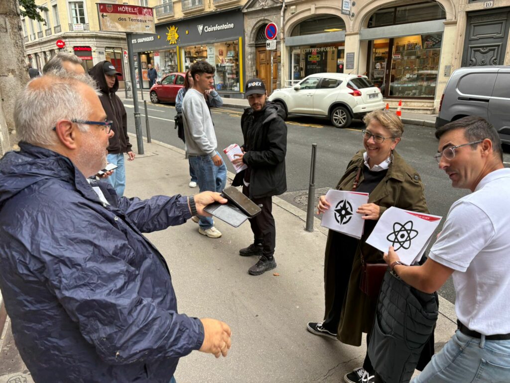 Deux équipes se rencontrent, un membre prend en photo les deux balises sur leur feuille de route