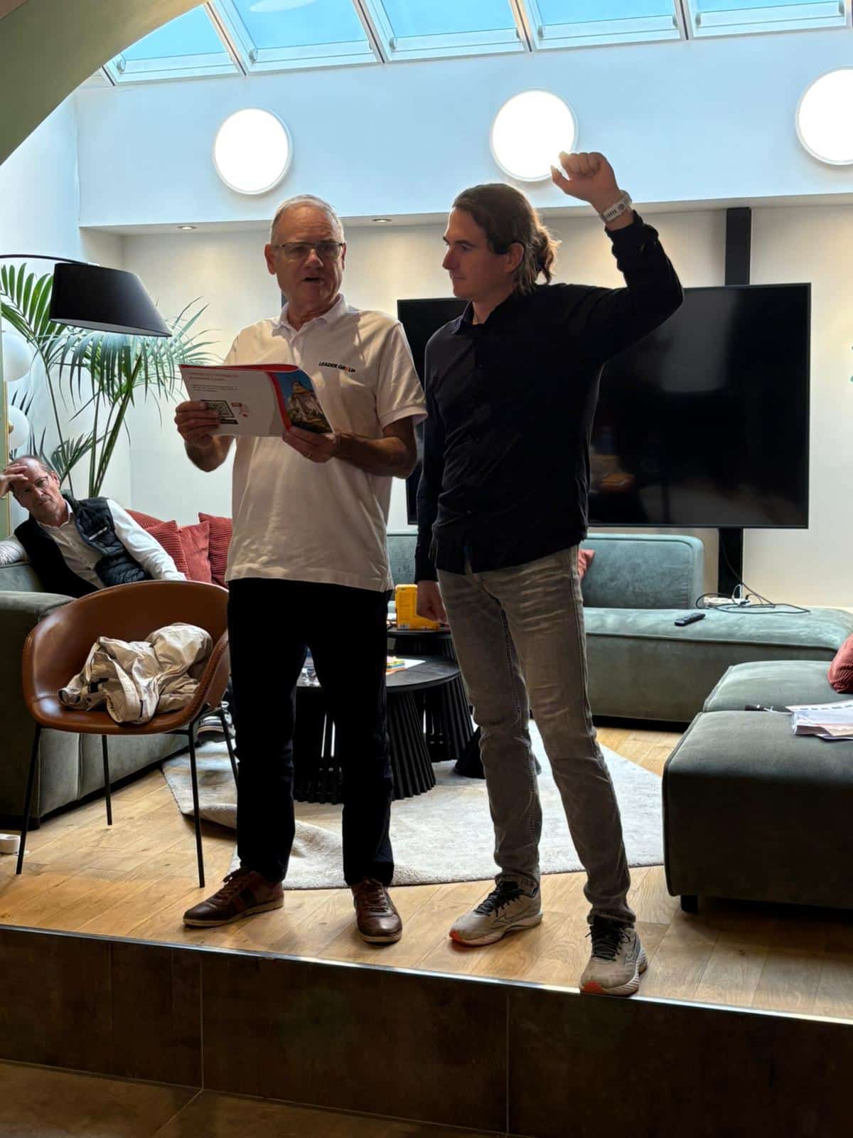 Photo de l'animateur Dominique à NoPlaceLikeWork avec un joueur à sa droite.