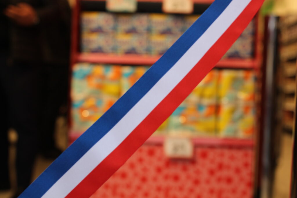 Bande horizontale bleu, blanc et rouge sur la devanture d’un magasin pour son inauguration