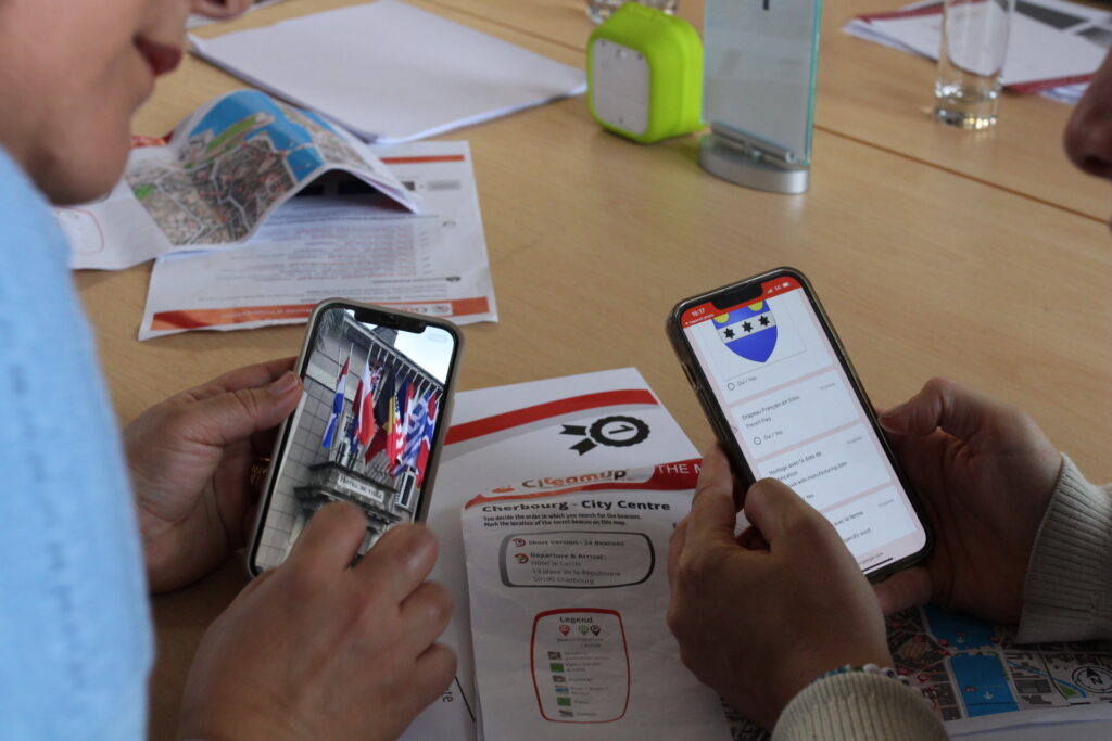 Deux participants corrigent leur jeu de piste avec leurs téléphones.